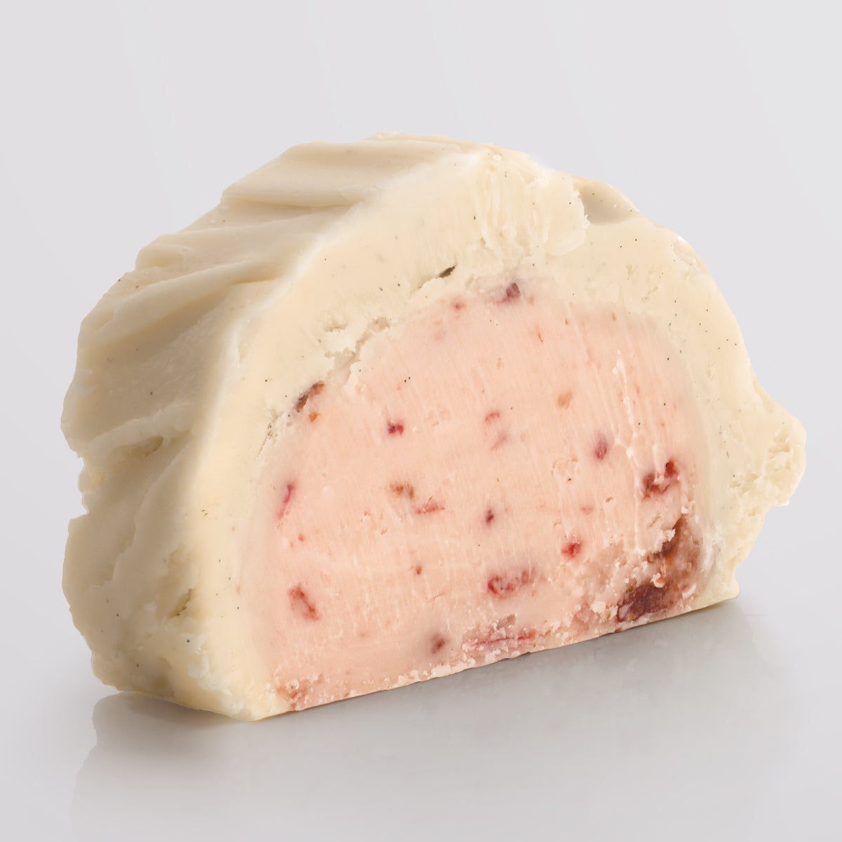 A slice of classic Strawberries & Cream Fudge showing the two layered fudge pairing a base of ripe strawberry fudge with a silky top tier of Madagascan vanilla fudge.