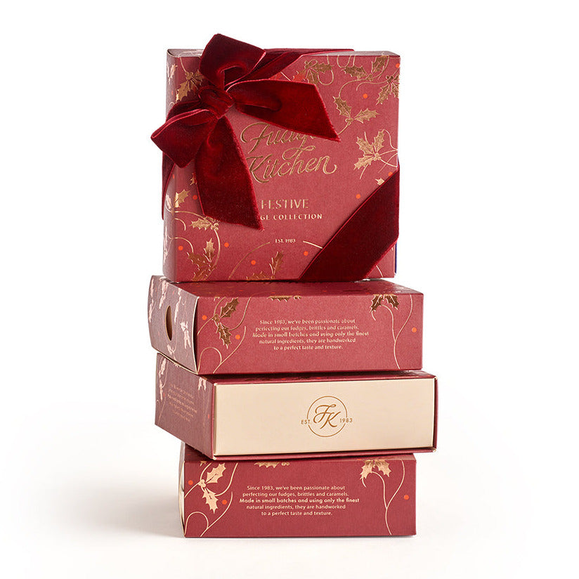 Stack of red Festive Fudge Selectiongift boxes with a bow on a white background
