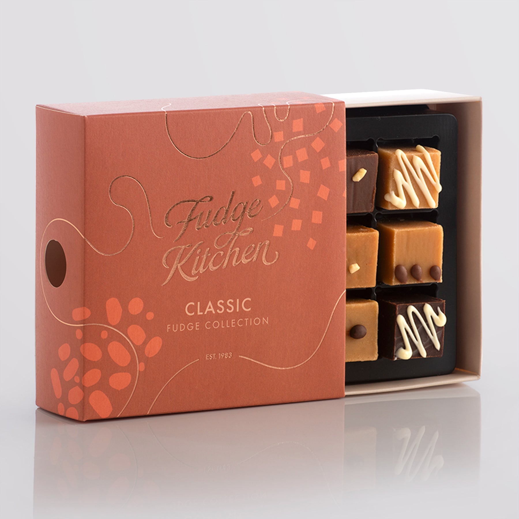 Fudge Kitchen, Classic Fudge Selection box, displayed on a light grey background, slightly open showing artisan fudge flavours.