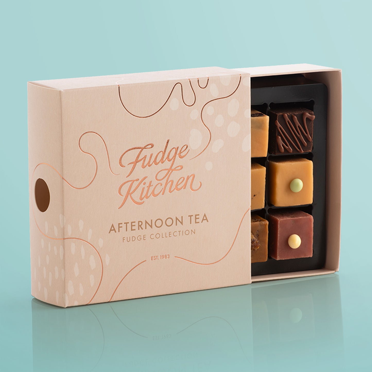Fudge Kitchen, Afternoon Tea Fudge Selection box, displayed on a light blue background, slightly open showing artisan fudge flavours.