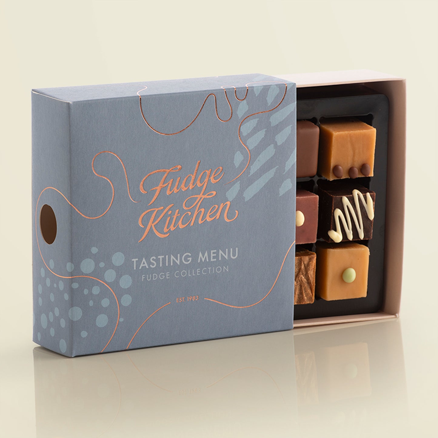 Fudge Kitchen, Tasting Menu Fudge Selection box, displayed on a light yellow background, slightly open showing artisan fudge flavours.