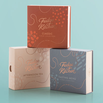 Three Fudge Kitchen product boxes on a light blue background