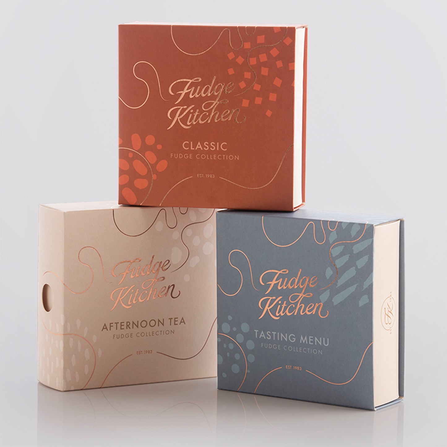 3 Fudge Kitchen Fudge Selection Boxes: Afternoon Tea, Classic, Tasting Menu - on a light grey background.