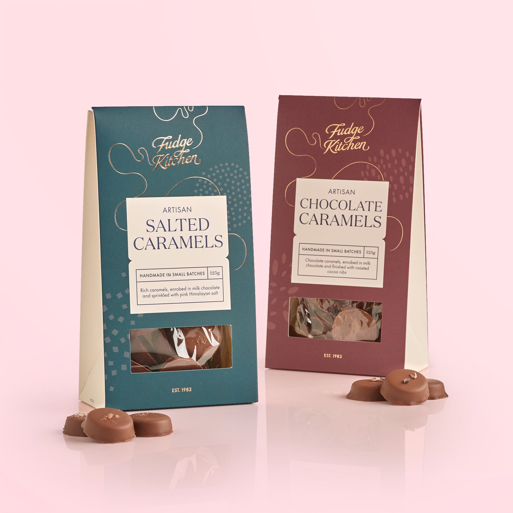 Two packages of Fudge Kitchen salted caramels and chocolate caramels on a light pink background.