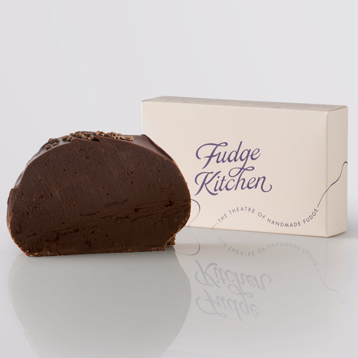Chocolate Rum Fudge, a Fudge Kitchen indulgent, handmade fudge flavour with crumbled topping and a 'Fudge Kitchen' box on a light gray background.