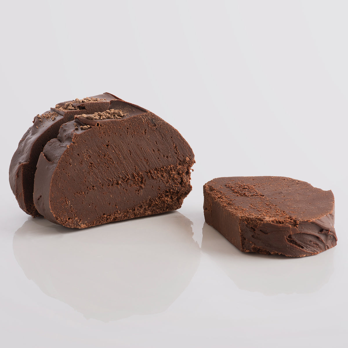 Three slices of chocolate rum fudge, a Fudge Kitchen indulgent, handmade fudge flavour with crumbled topping on a white background.