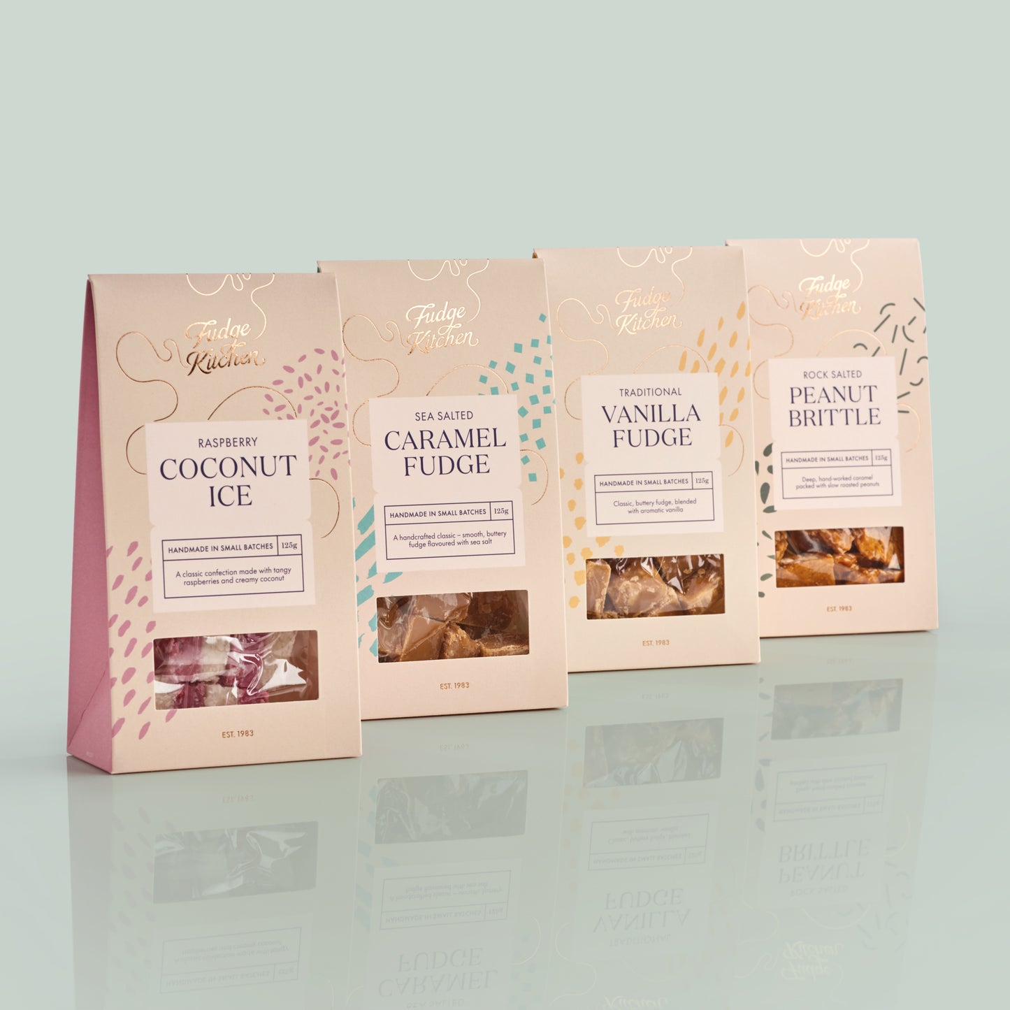 Four packages of Fudge Kitchen confectionery on a light gray background