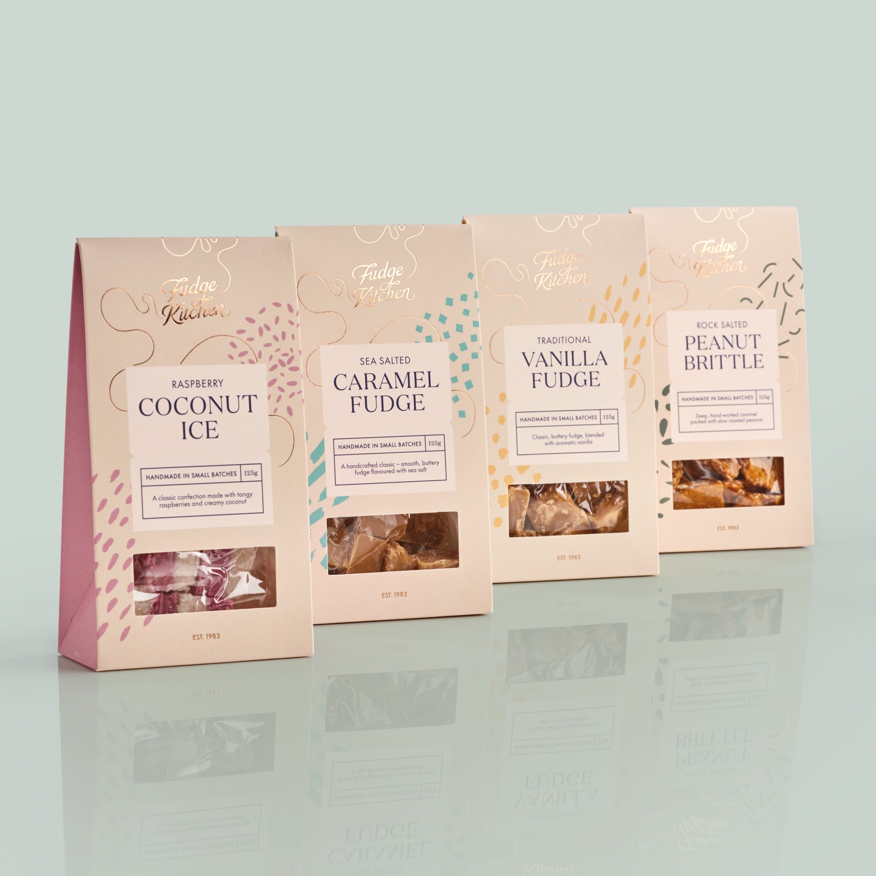 Four packages of Fudge Kitchen confectionery on a light gray background