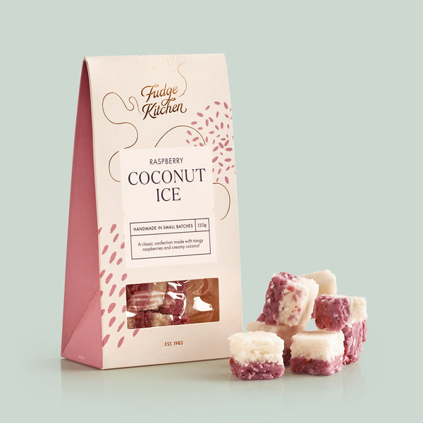 Fudge Kitchen raspberry coconut ice packaging with fudge pieces on a light green background