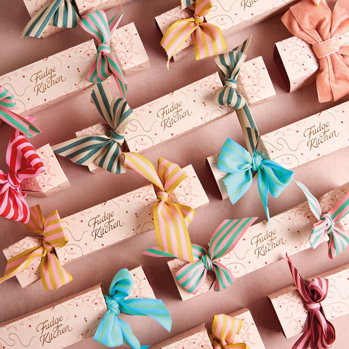 Fudge Kitchen luxury fudge crackers with colorful bows on a peach background