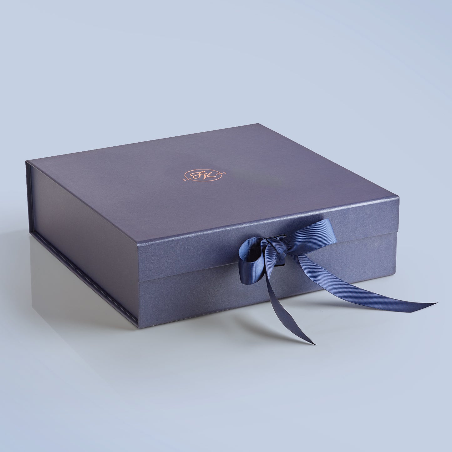 Elegant Fudge Kitchen hamper box with satin ribbon closure displayed on a light blue background, designed to beautifully present our handmade fudge for any special occasion. 