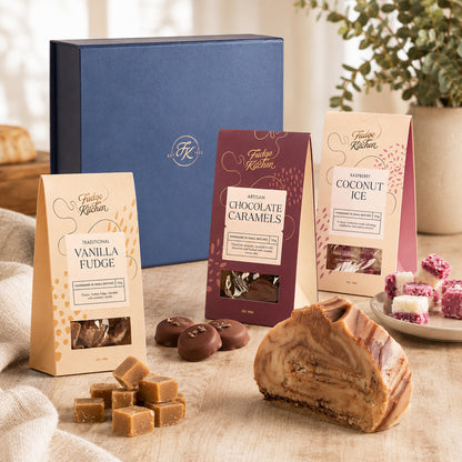 Assorted Fudge Kitchen confectionery items including fudge, caramels, and coconut ice on a wooden surface with a blurred background.
