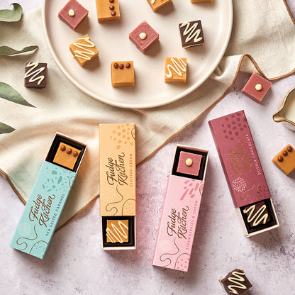 Four gourmet fudge sliders on a concrete table top, featuring rich chocolate, sea salt caramel, strawberries & cream and clotted cream, styled with handcrafted fudges displayed on a plate.