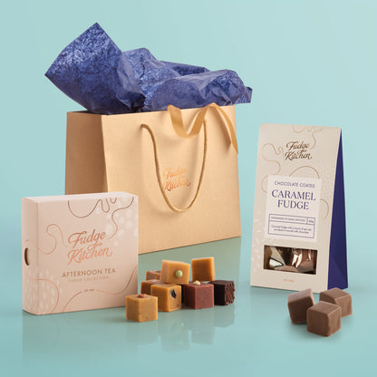 Assorted Fudge Kitchen confectionery items including fudge and caramels on a light blue background.