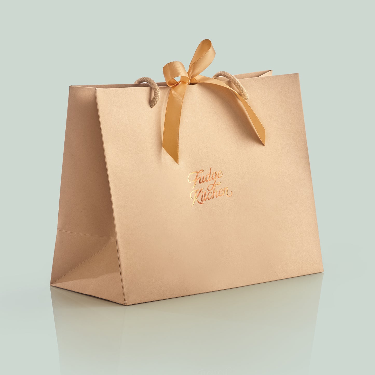 Elegant Fudge Kitchen gift bag with satin ribbon closure displayed on a light green background, designed to beautifully present our handmade fudge for any special occasion. 