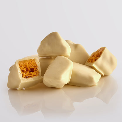 Close-up of the White Chocolate Honeycomb pieces by Fudge Kitchen, highlighting golden honeycomb chunks with a crisp texture and a rich white chocolate coating. A delicious indulgence for sweet lovers.