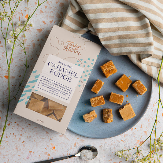 Sea Salted Caramel Fudge displayed on a plate, set in a warm, lifestyle table setting. A luxurious treat for sharing or gifting.