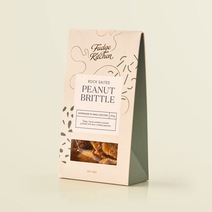 Packaging of Fudge Kitchen rock salted peanut brittle on a light beige background