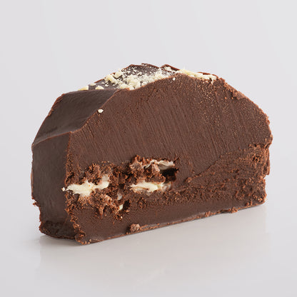 Slice of Fudge Kitchen Double Chocolate Fudge topped with a white chocolate on a blank background.