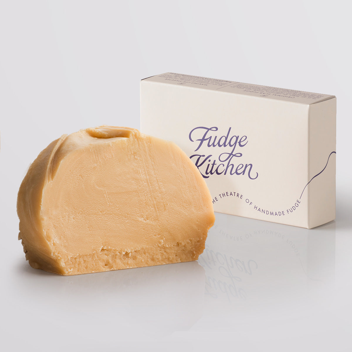 Irish Cream Fudge single slice and a single slice fudge box in the background, a Fudge Kitchen indulgent, handmade fresh fudge flavour displayed on a grey background.