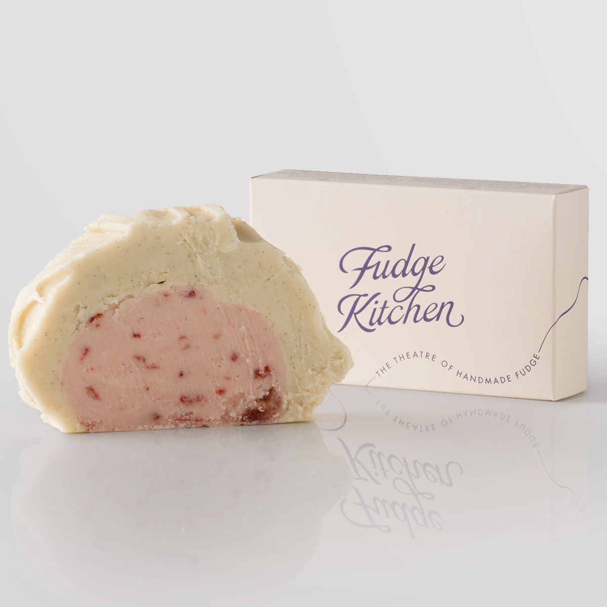 Strawberries & Cream Fudge showing the two layers of fudge with a base of ripe strawberry fudge with a silky top tier of Madagascan vanilla fudge next to a single slice gift box.