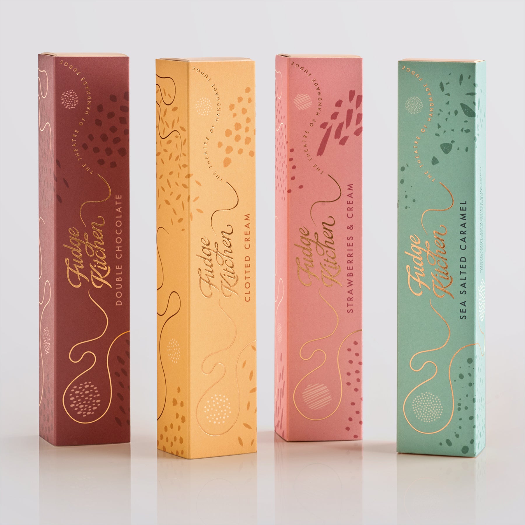 Four Fudge Kitchen fudge gift slider boxes in different colours on a white background