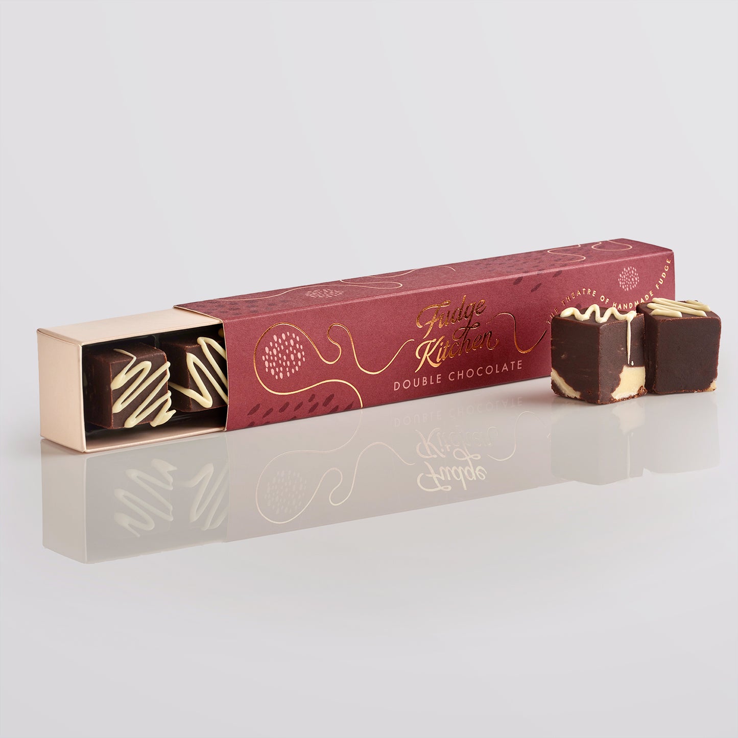 Double chocolate fudges in a branded box on a reflective surface with a light gray background