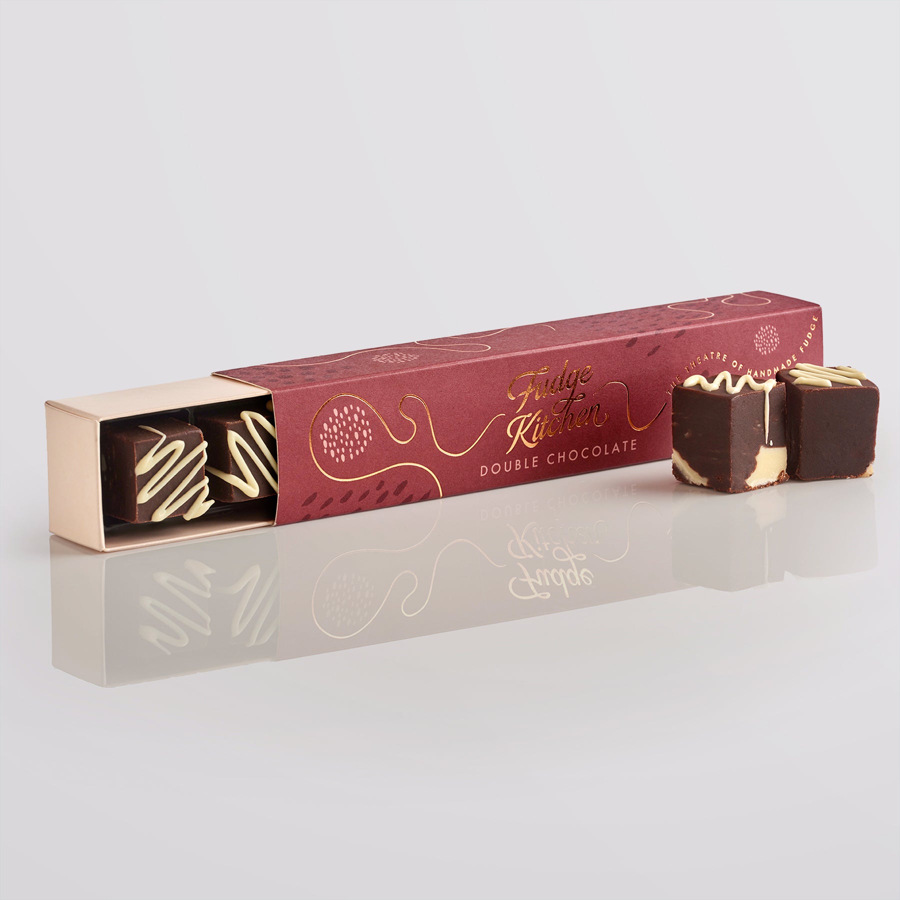 Double chocolate fudges in a branded box on a reflective surface with a light gray background