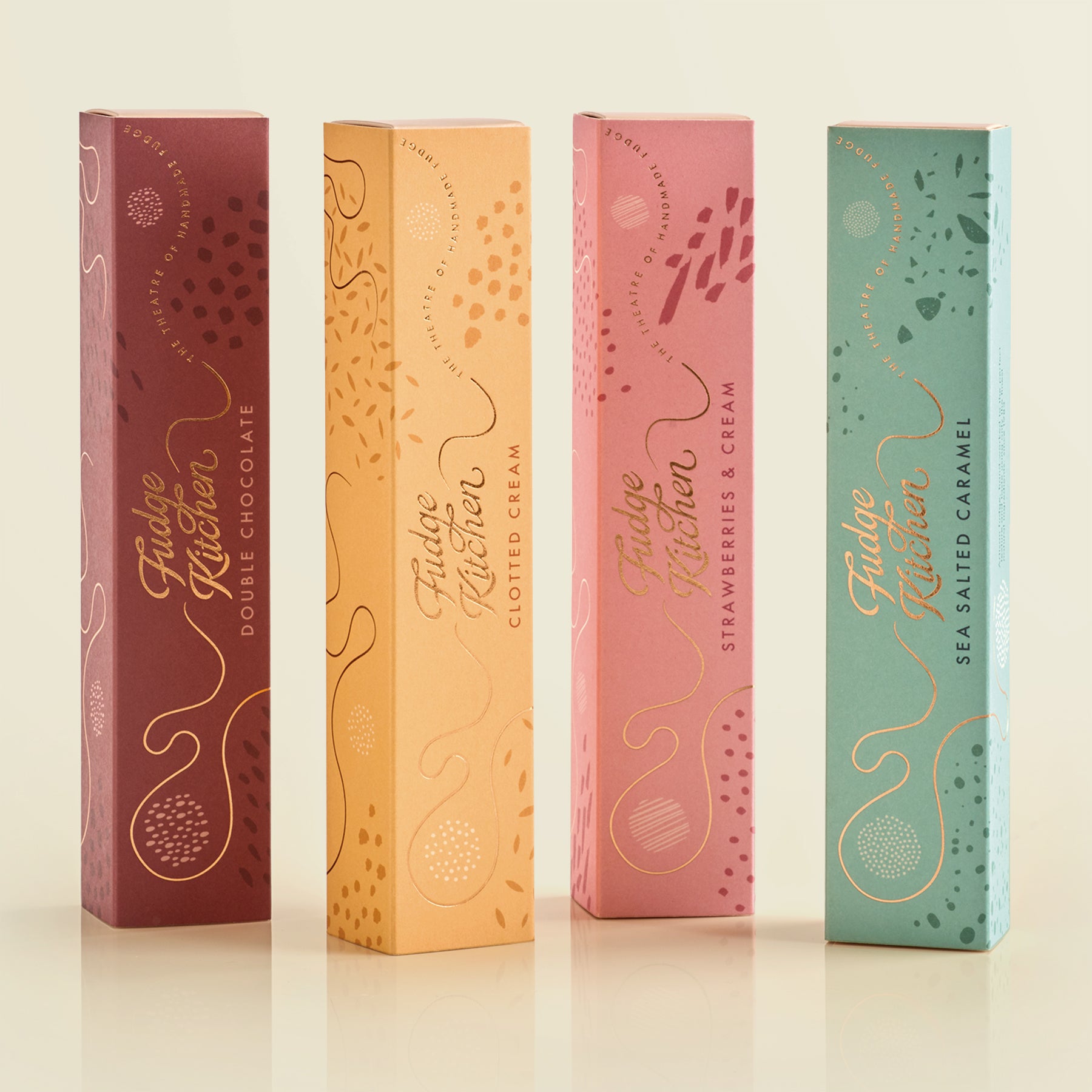 Four Fudge Kitchen fudge gift boxes in different flavors on a light background