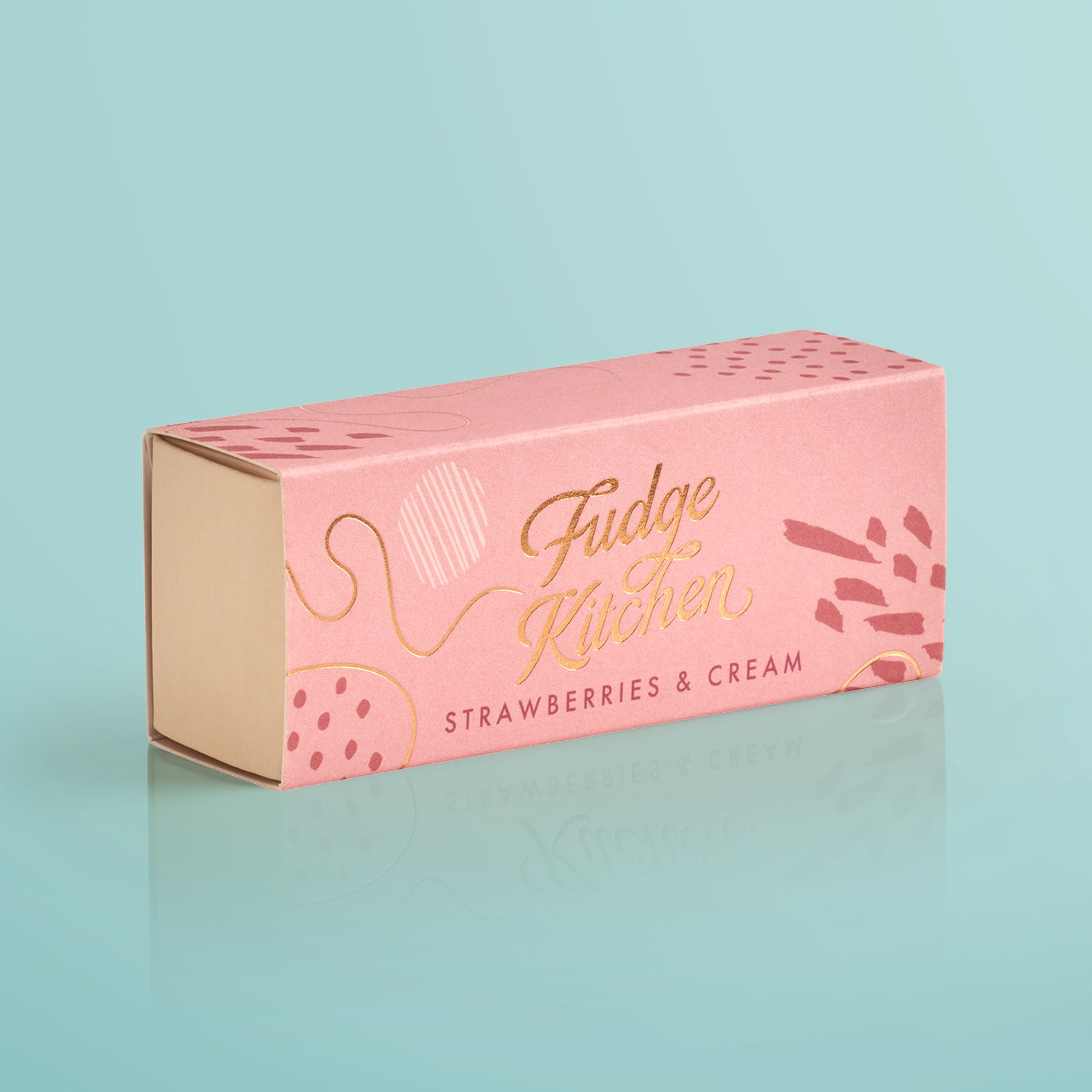 Pink fudge box with 'Fudge Kitchen' and 'Strawberries & Cream' text on a light blue background