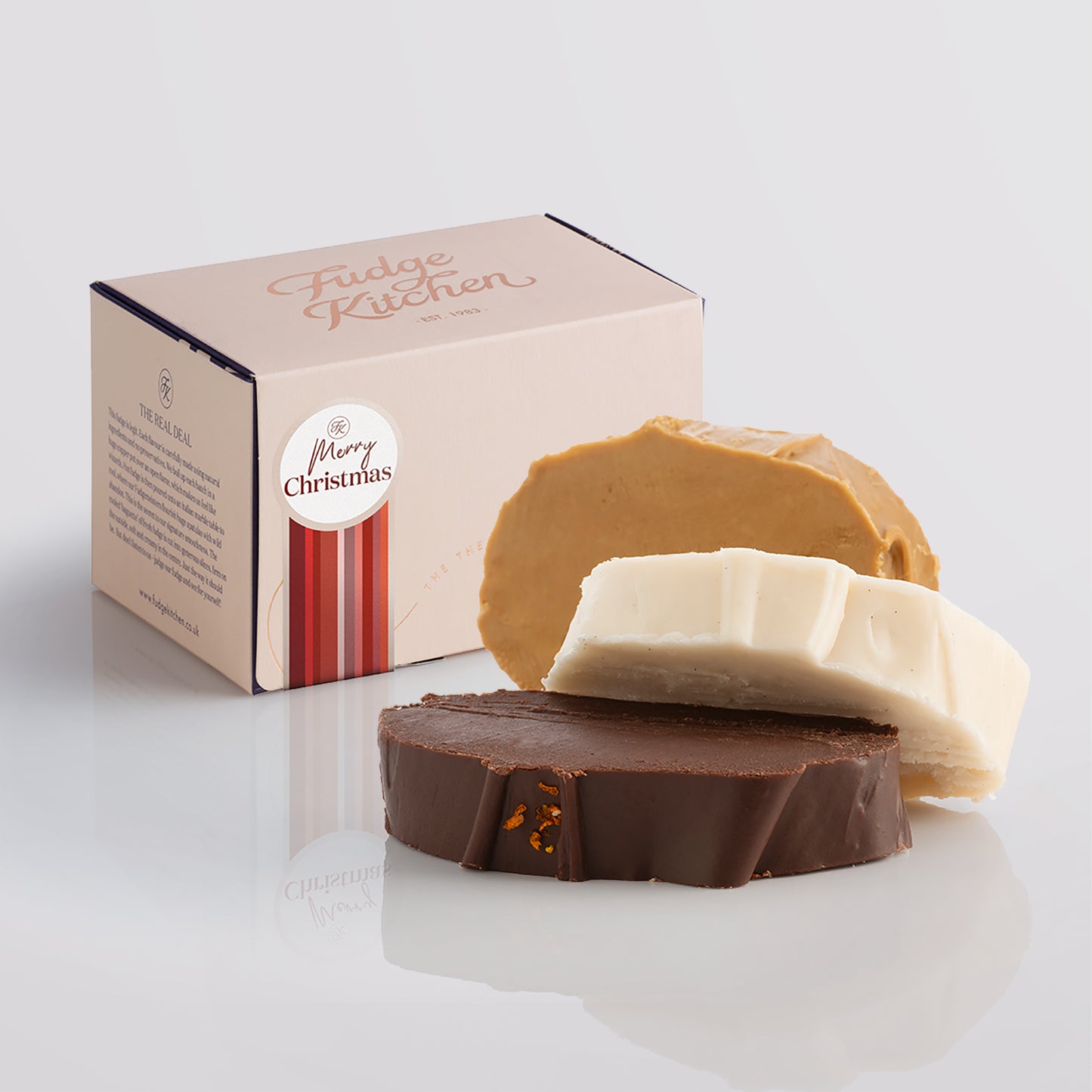 Vegan fudge trio elegantly displayed in a buff-coloured gift box with gilded accents with a 'Happy Christmas' box seal.
