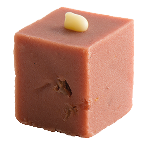 Square piece of strawberries & cream fudge with a small white chocolate drop decoration on top against a white background.
